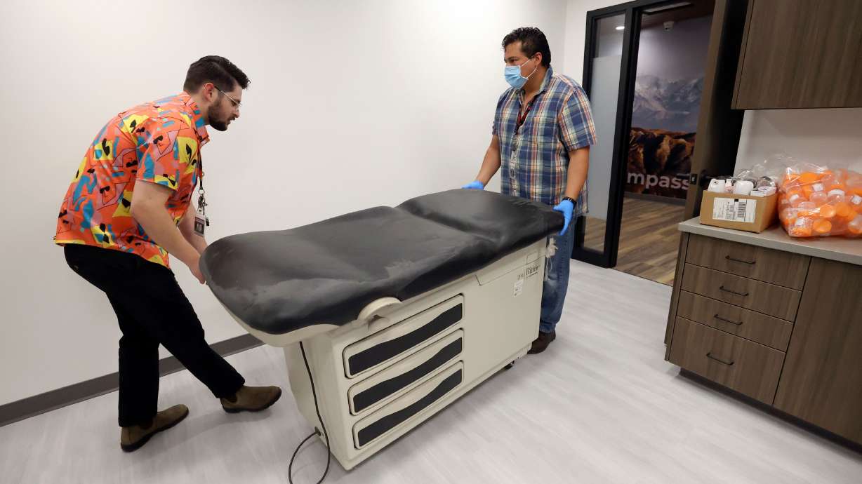 Andrew Grover, Sacred Circle Healthcare marketing specialist, and Diego Arellano, Sacred Circle Healthcare IT support, move a bed into an exam room that will be used for medical substance abuse treatment at Sacred Circle Healthcare’s new substance abuse clinic in Salt Lake City on May 11.