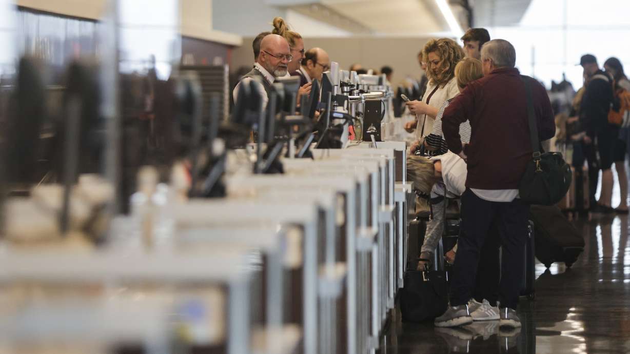 A Delta employee helps travelers check in at the Salt Lake City International Airport in Salt Lake City on April 19. AAA projects a rise in Memorial Day weekend travel at the end of the month.