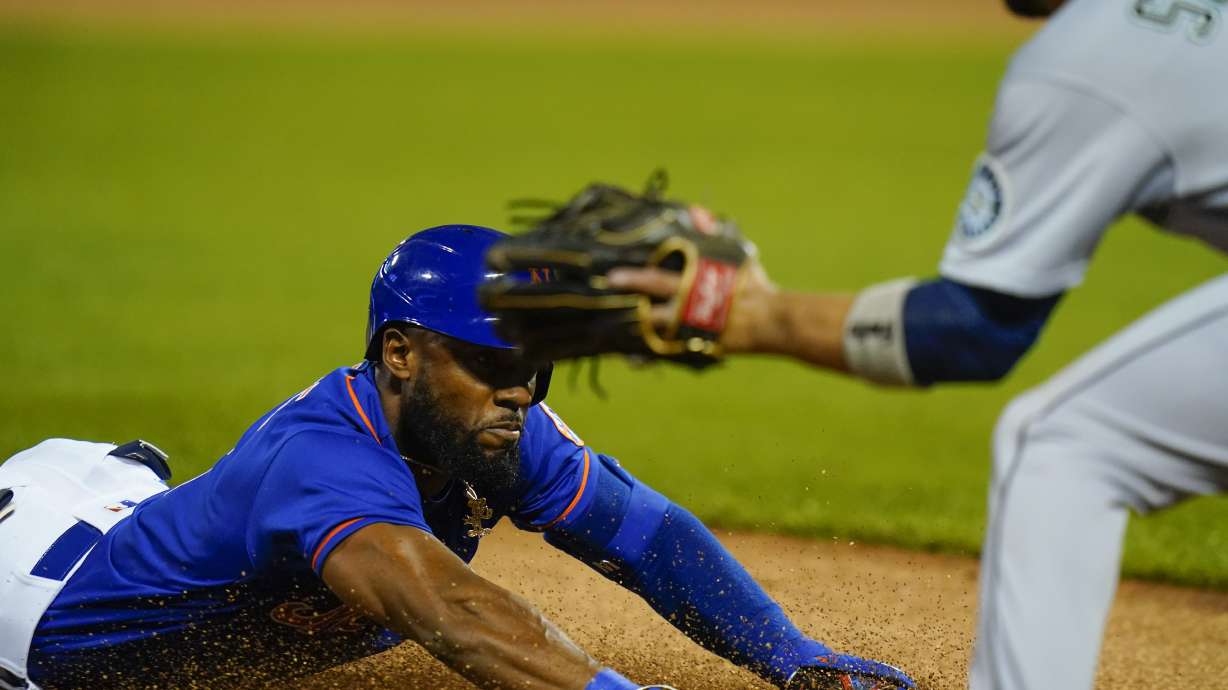 New York Mets' Starling Marte slides to third base during the first inning of a baseball game against the Seattle Mariners, Saturday, May 14, 2022, in New York. After review, Marte was called safe at third for a triple.