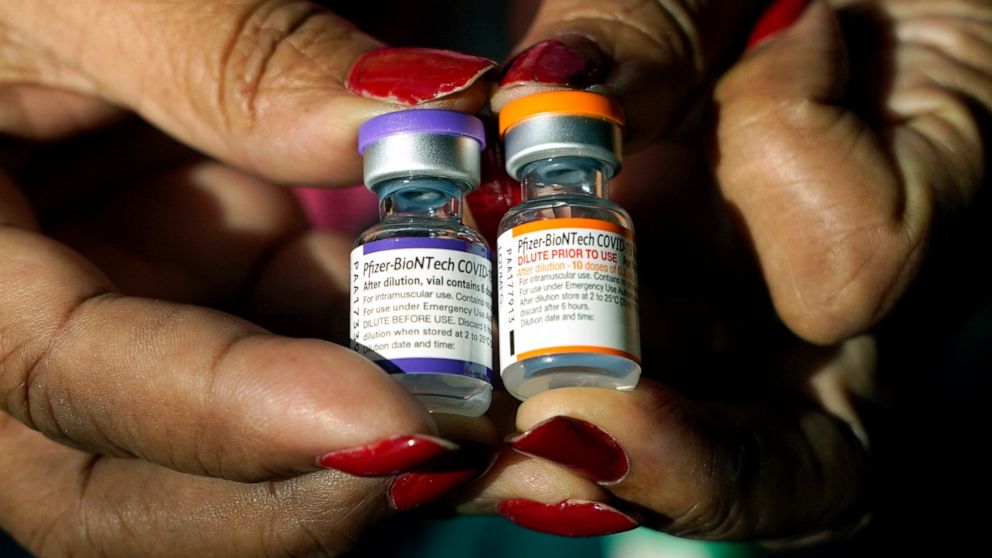 A nurse holds a vial of the Pfizer COVID-19 vaccine for children ages 5 to 11, right, and a vial of the vaccine for adults, which has a different colored label, at a vaccination station in Jackson, Miss., Feb. 8. U.S. regulators authorized a COVID-19 booster shot for healthy 5- to 11-year-olds on Tuesday.