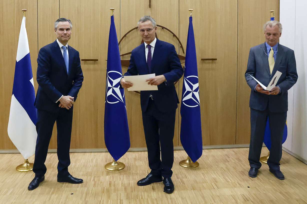 Finland's Ambassador to NATO Klaus Korhonen, left, NATO Secretary-General Jens Stoltenberg and Sweden's Ambassador to NATO Axel Wernhoff attend a ceremony to mark Sweden's and Finland's application for membership in Brussels, Belgium, Wednesday.