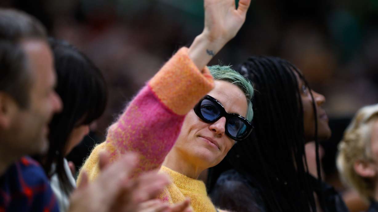 Soccer player Megan Rapinoe waves to the crowd during the second quarter of a WNBA basketball game between the Minnesota Lynx and the Seattle Storm on May 6, in Seattle. The U.S. Soccer Federation has reached milestone agreements to pay its men's and women's teams equally. That makes the American national governing body the first in the sport to promise both sexes matching money.