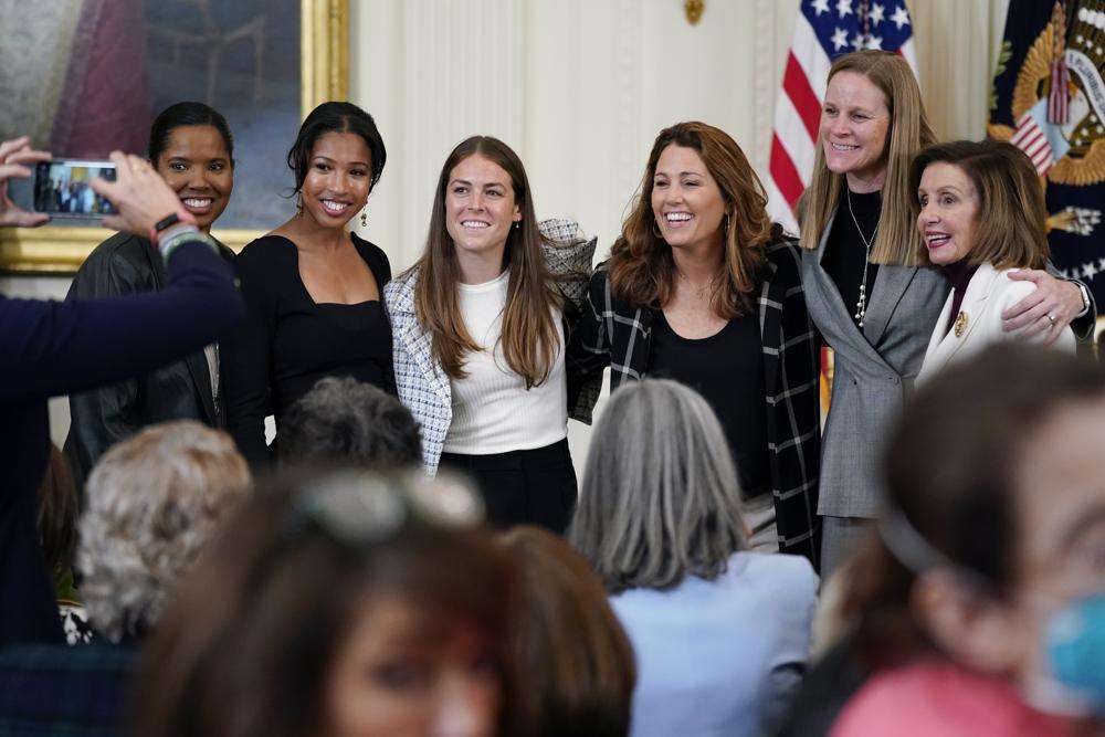 Former members and members of the U.S. Women's National soccer team, from left, Briana Scurry, Margaret 'Midge' Purce, Kelley O'Hara, Julie Foudy, and Cindy Parlow Cone, President of U.S. Soccer, pose for a photo with House Speaker Nancy Pelosi of Calif., before an event to celebrate Equal Pay Day and Women's History Month in the East Room of the White House, March 15, in Washington. The U.S. Soccer Federation reached milestone agreements to pay its men's and women's teams equally.