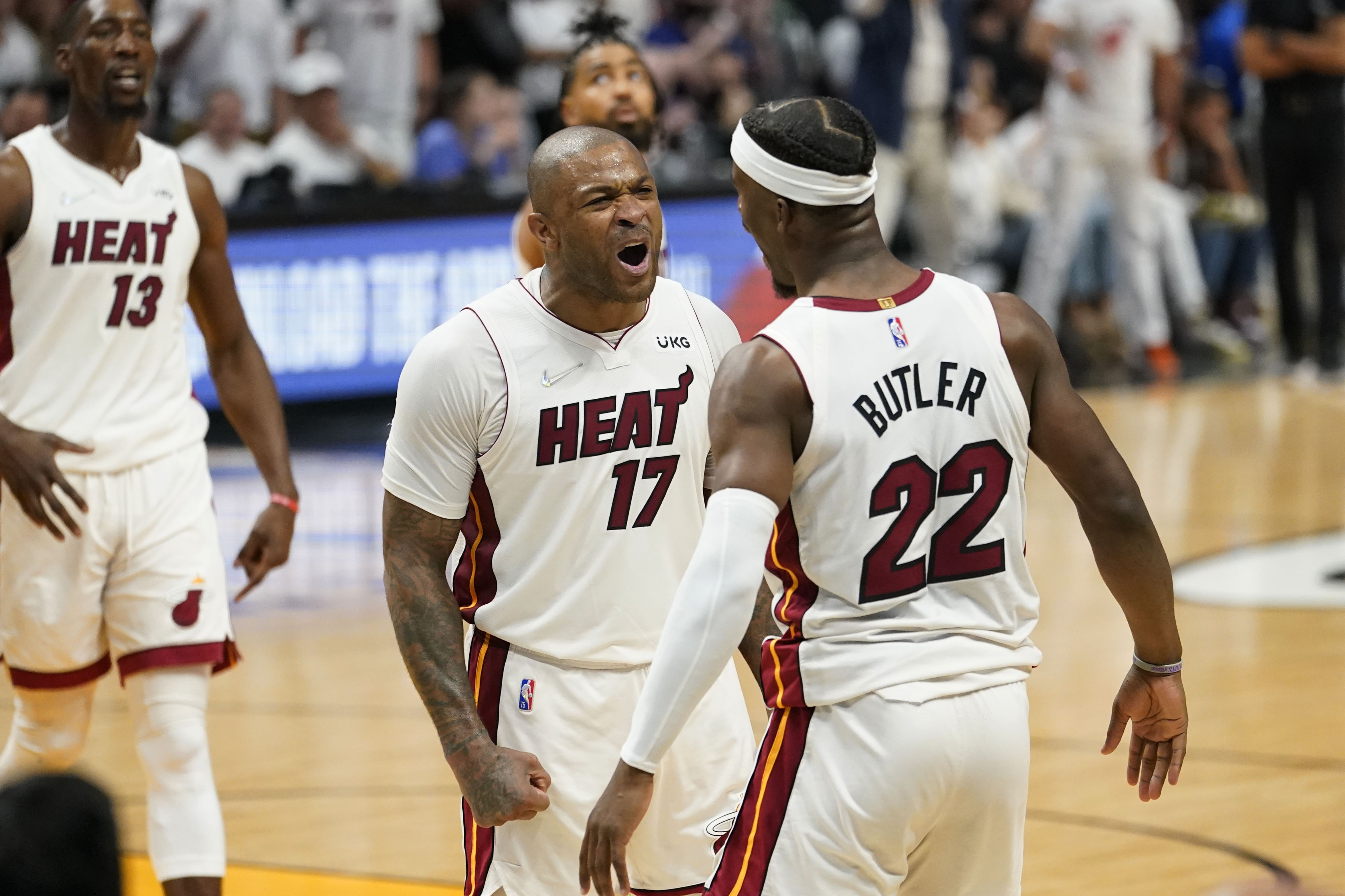 Miami Heat forward P.J. Tucker (17) and forward Jimmy Butler (22) celebrate during the second half of Game 1 of an NBA basketball Eastern Conference finals playoff series against the Boston Celtics, Tuesday, May 17, 2022, in Miami. 