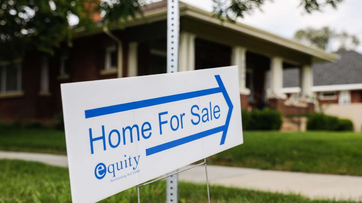 A home for sale sign is displayed outside of a house in the Sugar House neighborhood of Salt Lake City on Sept. 23, 2021. Mortgage applications have dropped in the U.S. as a result of higher interest rates.
