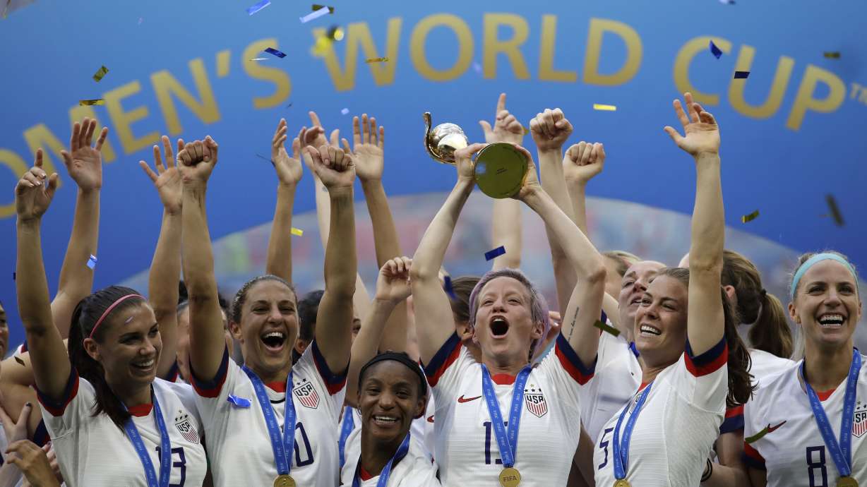 FILE - United States' Megan Rapinoe lifts up the trophy after winning the Women's World Cup final soccer match between US and The Netherlands at the Stade de Lyon in Decines, outside Lyon, France, in July 7, 2019. The U.S. Soccer Federation reached milestone agreements to pay its men's and women's teams equally, making the American national governing body the first in the sport to promise both sexes matching money.