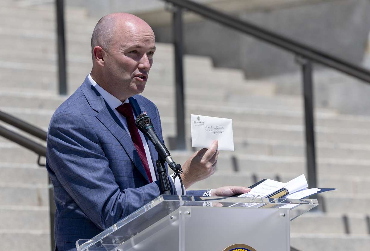 Gov. Spencer Cox holds up a letter he wrote to the people of Utah. The letter was placed inside a time capsule that will be stored inside one of the columns of the Capitol in Salt Lake City on Wednesday, May 18, 2022.