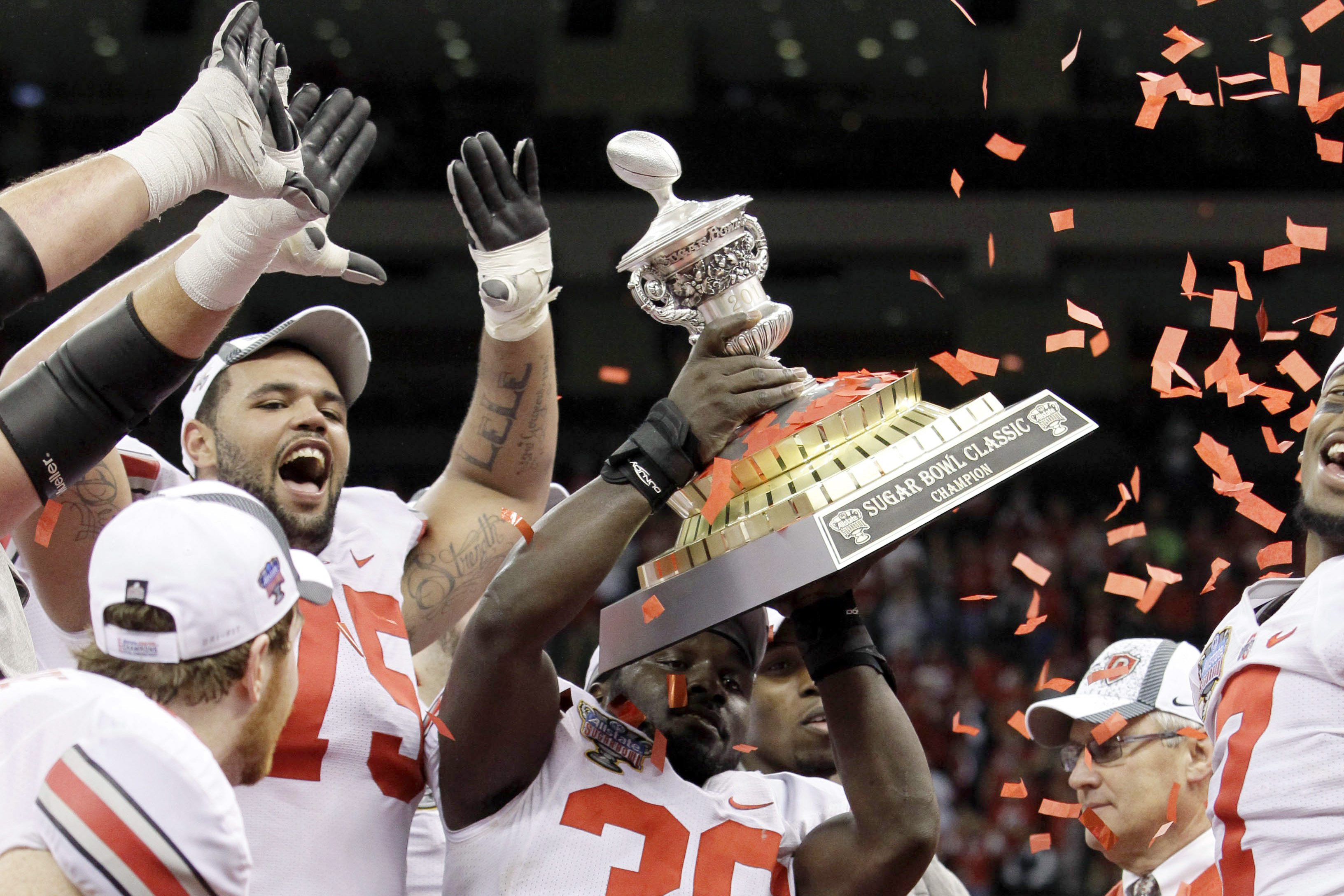 FILE - Ohio State linebacker Brian Rolle (36) holds up the Sugar Bowl trophy after they defeated Arkansas 31-26 during the Sugar Bowl NCAA college football game at the Louisiana Superdome in New Orleans, on Jan. 4, 2011. The 2010 season of the Ohio State University football team, vacated after a memorabilia-for-cash scandal, should be restored because of recent changes allowing college athletes to be compensated, under a symbolic resolution approved by Ohio lawmakers, Wednesday, May 18, 2022. 