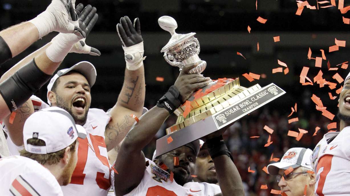 FILE - Ohio State linebacker Brian Rolle (36) holds up the Sugar Bowl trophy after they defeated Arkansas 31-26 during the Sugar Bowl NCAA college football game at the Louisiana Superdome in New Orleans, on Jan. 4, 2011. The 2010 season of the Ohio State University football team, vacated after a memorabilia-for-cash scandal, should be restored because of recent changes allowing college athletes to be compensated, under a symbolic resolution approved by Ohio lawmakers, Wednesday, May 18, 2022.