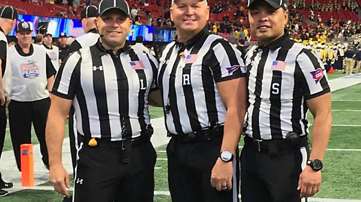 In this Dec. 29, 2018 photo provided by Lo van Pham, from left, line judge Derek Anderson, referee Mike Defee and side judge Lo van Pham pose for a photo before the Peach Bowl NCAA college football game in Atlanta. Lo van Pham’s journey to the NFL began when he fell in love with sports upon arriving in Texas after living in refugee camps with his family. More than 40 years later, van Pham is set to become the first Asian American to officiate in the NFL.
