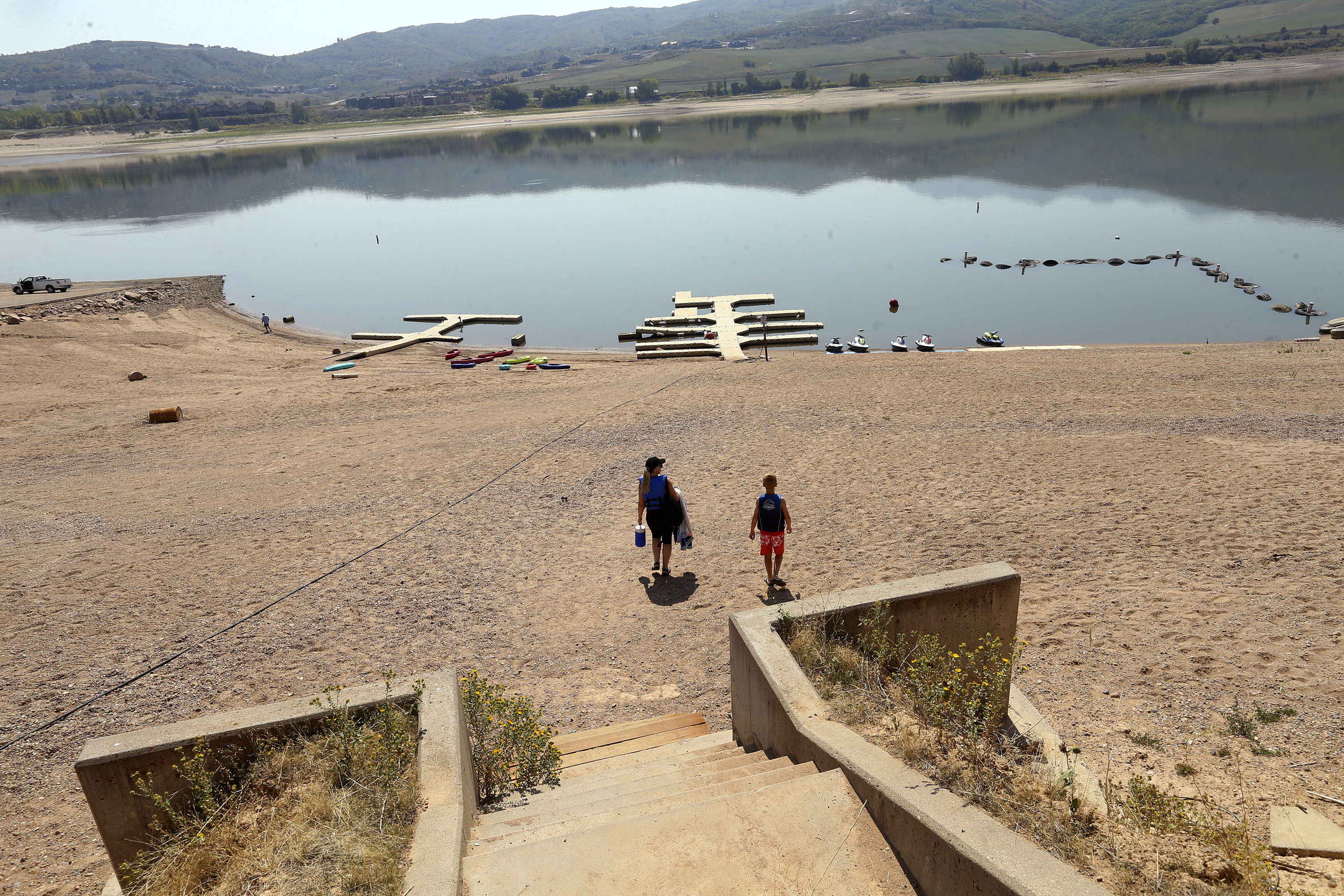 People make the walk from a watercraft rental shop to the water at Pineview Reservoir near Huntsville, Weber County, on Sept. 9, 2021. Reservoir levels are expected to decline further this summer, especially with an outlook published Thursday forecasting hot conditions for the next three months.