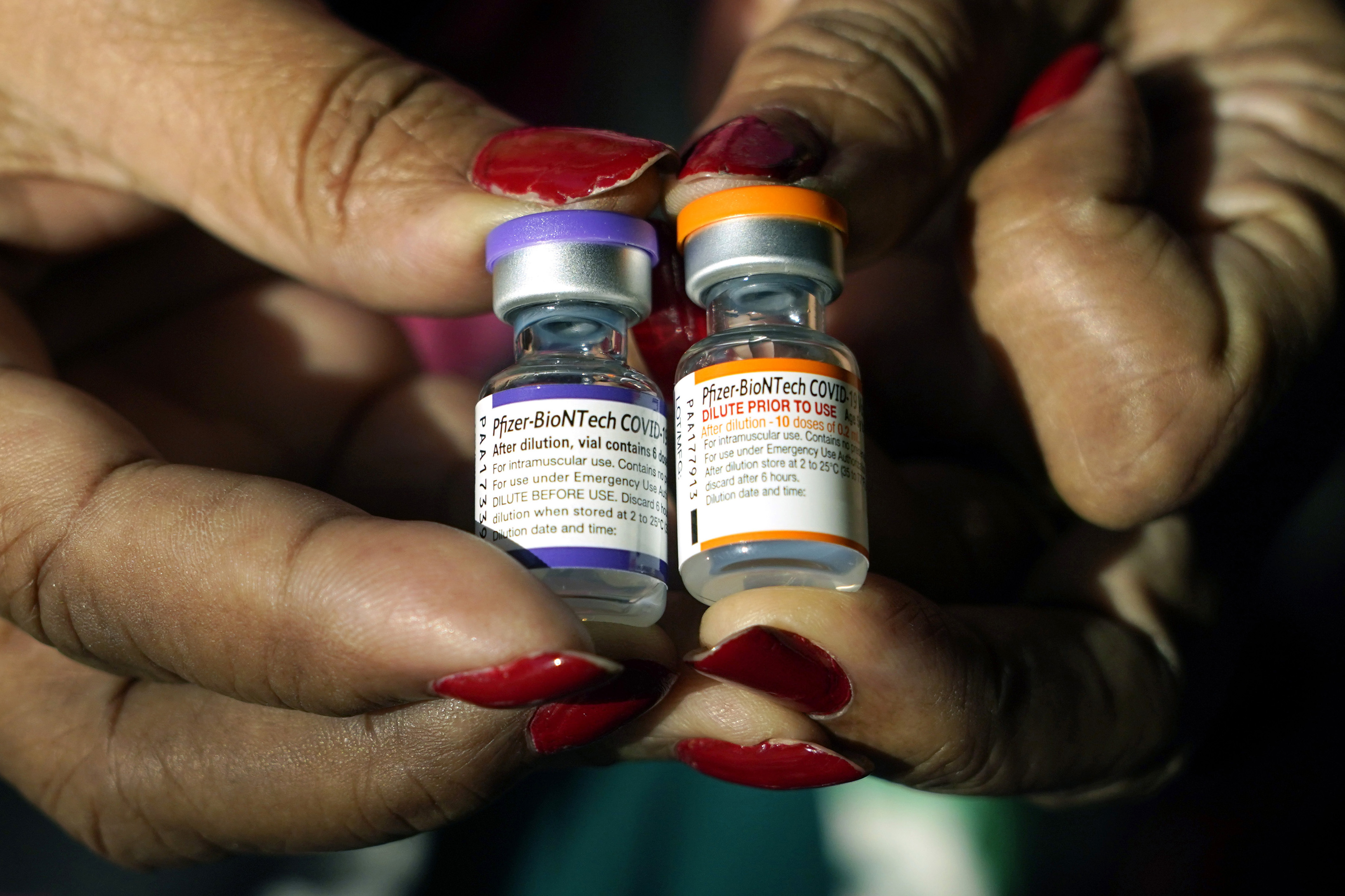 A nurse holds a vial of the Pfizer COVID-19 vaccine for children ages 5 to 11, right, and a vial of the vaccine for adults, at a vaccination station in Jackson, Miss., Feb. 8. U.S. regulators authorized a COVID-19 booster shot for healthy 5- to 11-year-olds on Thursday.