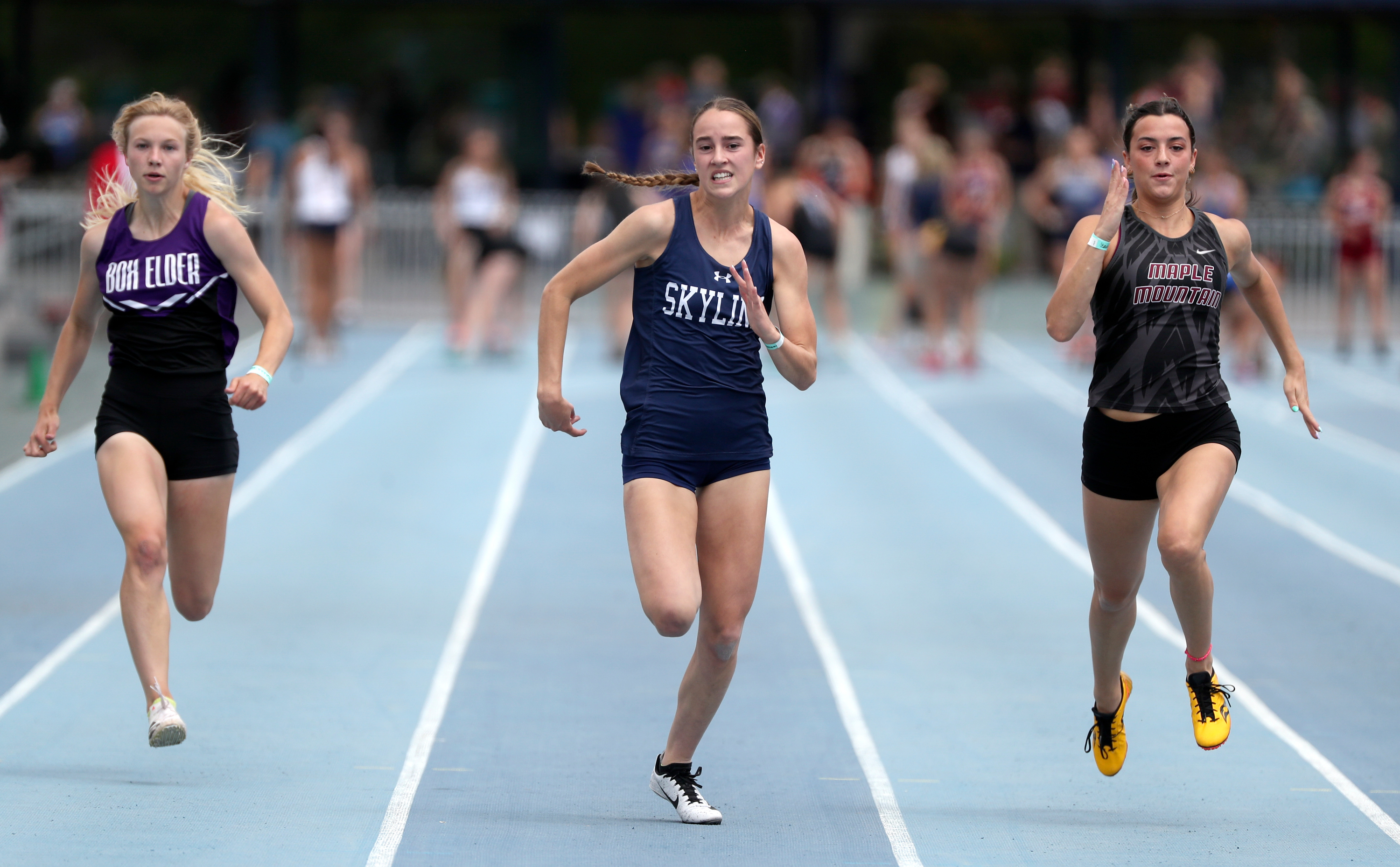 Skyline’s Lily Boyden, center, wins the girls 100-meter race at the 5A track state championships at the Clarence F. Robison Outdoor Track and Field Complex in Provo, on Thursday, May 19, 2022.