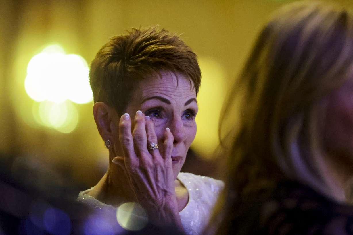 Janet Pickup, wife of Ray Pickup, former CEO of WCF Insurance, wipes tears away as Ray speaks during the Salt Lake Chamber Annual Award banquet in Salt Lake City on Thursday.