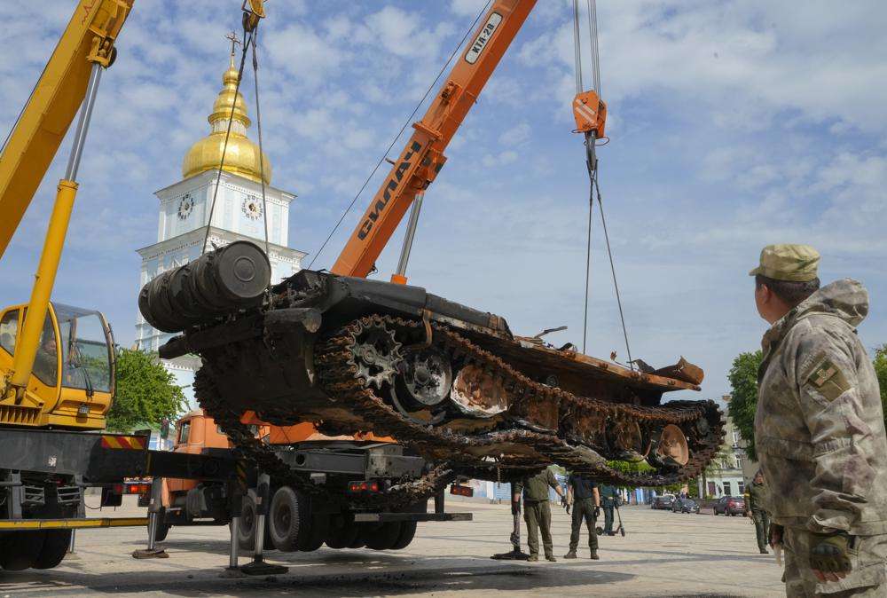 Ukrainian soldiers unload a destroyed Russian tank to install it as a symbol of war in central Kyiv, Ukraine, Friday. St Michael cathedral is in the background. Russia claims to have captured Mariupol in what would be its biggest victory yet in its war with Ukraine.