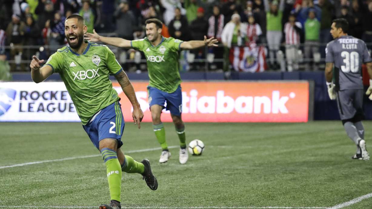 FILE - Seattle Sounders forward Clint Dempsey, left, celebrates after he scored a goal on Guadalajara goalkeeper Rodolfo Cota, right, during the second half of a CONCACAF Champions League soccer match Wednesday, March 7, 2018, in Seattle. Four years removed from playing, Dempsey is set to be inducted into the U.S. National Soccer Hall of Fame on Saturday, May 21, 2022.