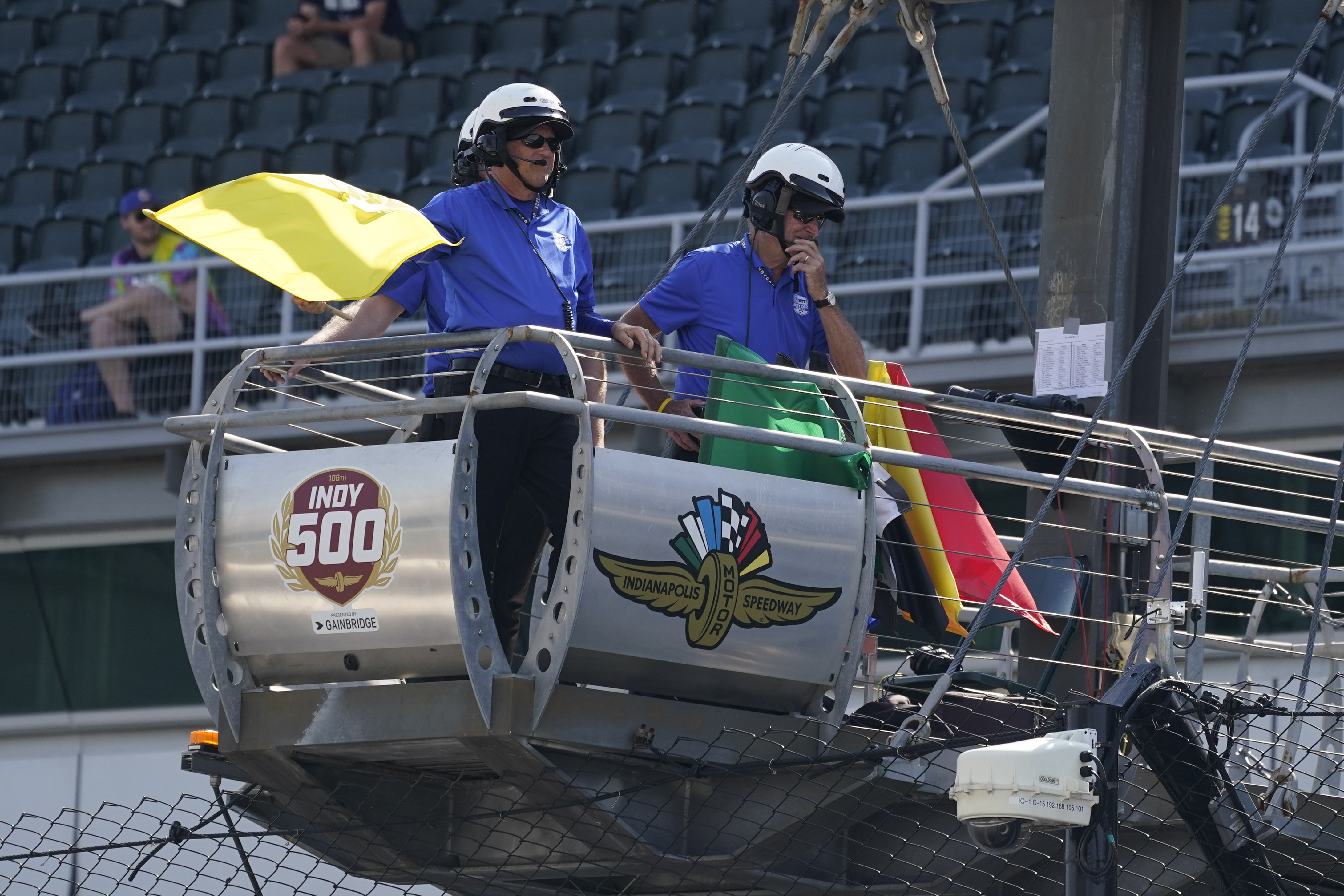 An official hold the yellow flag as it blows in the wind during practice for the Indianapolis 500 auto race at Indianapolis Motor Speedway, Friday, May 20, 2022, in Indianapolis. 