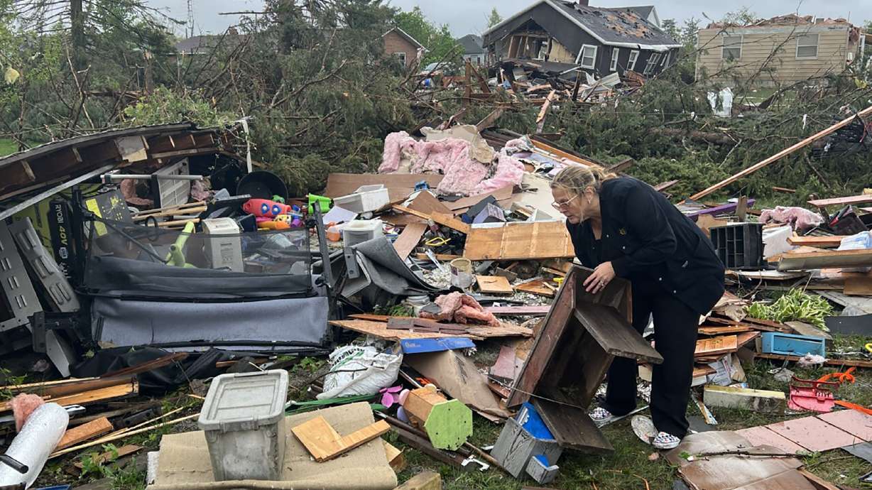 Theresa Haske sorts through debris from what was her garage after a tornado tore through Gaylord, Mich., Friday.