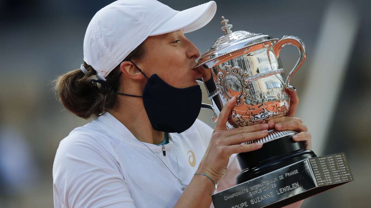 FILE - Poland's Iga Swiatek kisses the trophy after winning the final match of the French Open tennis tournament against Sofia Kenin of the U.S. in two sets, 6-4, 6-1, at the Roland Garros stadium in Paris, France, Saturday, Oct. 10, 2020. Swiatek was the 2020 champion at Roland Garros and was seeded No. 1 in the draw for this year’s tournament in Paris.