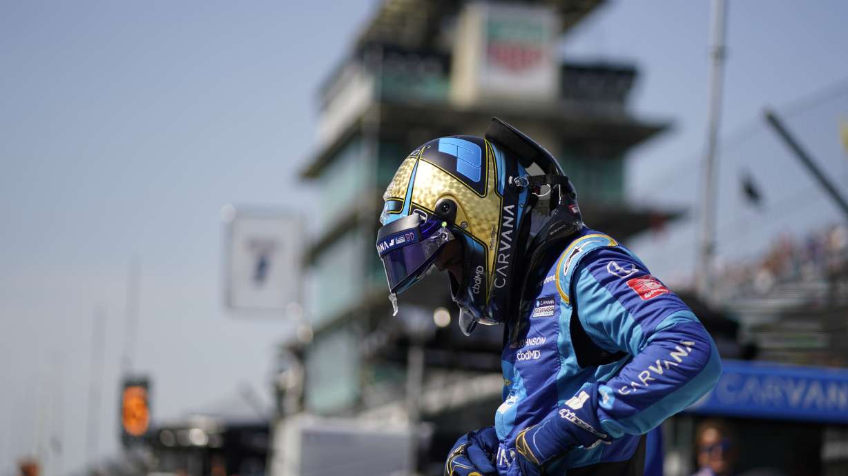Jimmie Johnson prepares to climb into his car during practice for the Indianapolis 500 auto race at Indianapolis Motor Speedway, Friday, May 20, 2022, in Indianapolis.