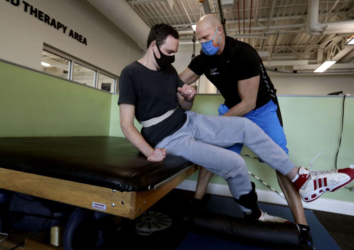 Spencer Brown and physical therapist Matt Hansen work on Brown’s ability to get up from the floor at Neuroworx in Sandy on Friday, Feb. 11. Brown is in rehabilitation for a spinal cord injury caused by an accident in July.
