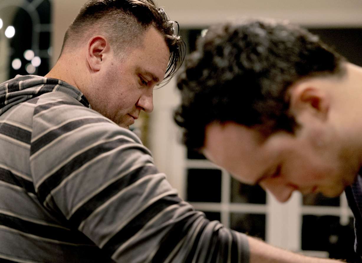 Clint Curtis, left, helps Spencer Brown with his physical therapy at Brown’s in-laws’ home in Alpine on Tuesday, April 19. Friends and neighbors come over every evening to help Brown.