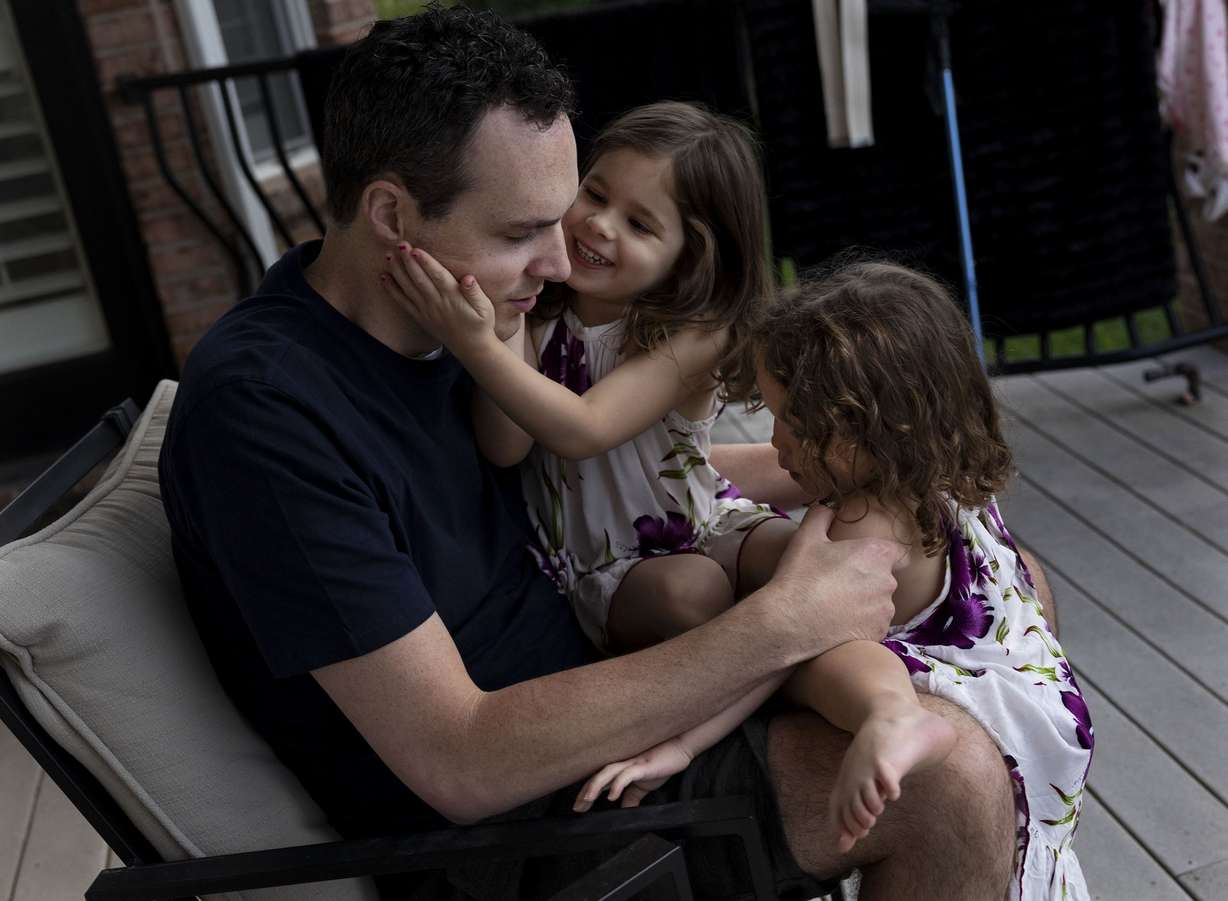 Spencer Brown’s daughters, Isla, 4, and Aurora, 2, climb into his lap in Alpine on Thursday, May 5.