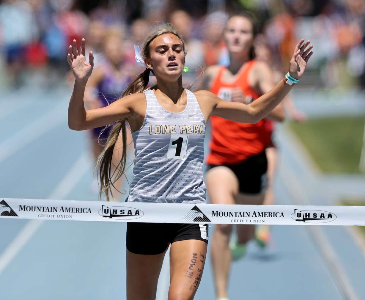 Lone Peak's Taylor Rohatinsky breaks the tape at the 6A high school state championships at BYU in Provo on Saturday, May 21, 2022.