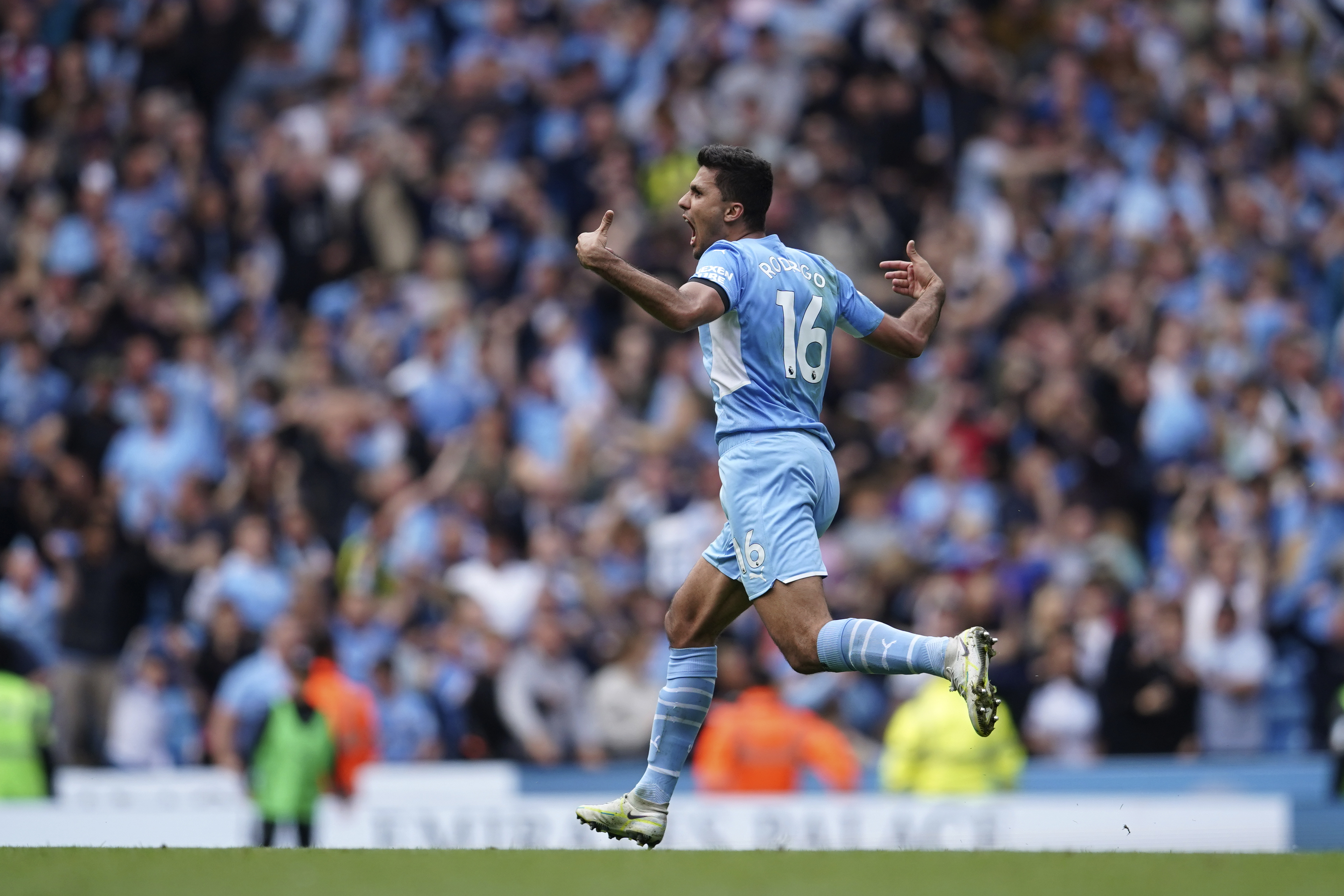 Manchester City's Rodrigo runs to celebrate after scoring his sides second goal during the English Premier League soccer match between Manchester City and Aston Villa at the Etihad Stadium in Manchester, England, Sunday, May 22, 2022. 