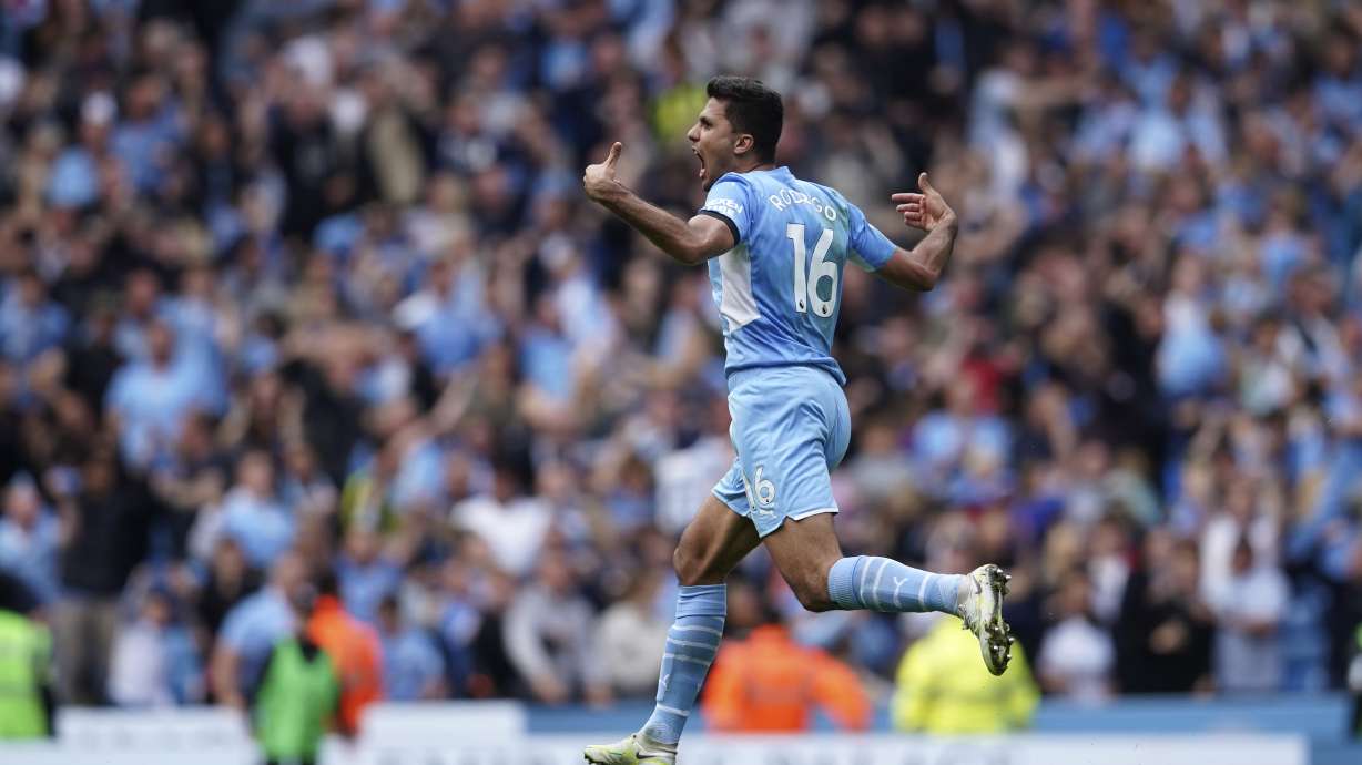 Manchester City's Rodrigo runs to celebrate after scoring his sides second goal during the English Premier League soccer match between Manchester City and Aston Villa at the Etihad Stadium in Manchester, England, Sunday, May 22, 2022.