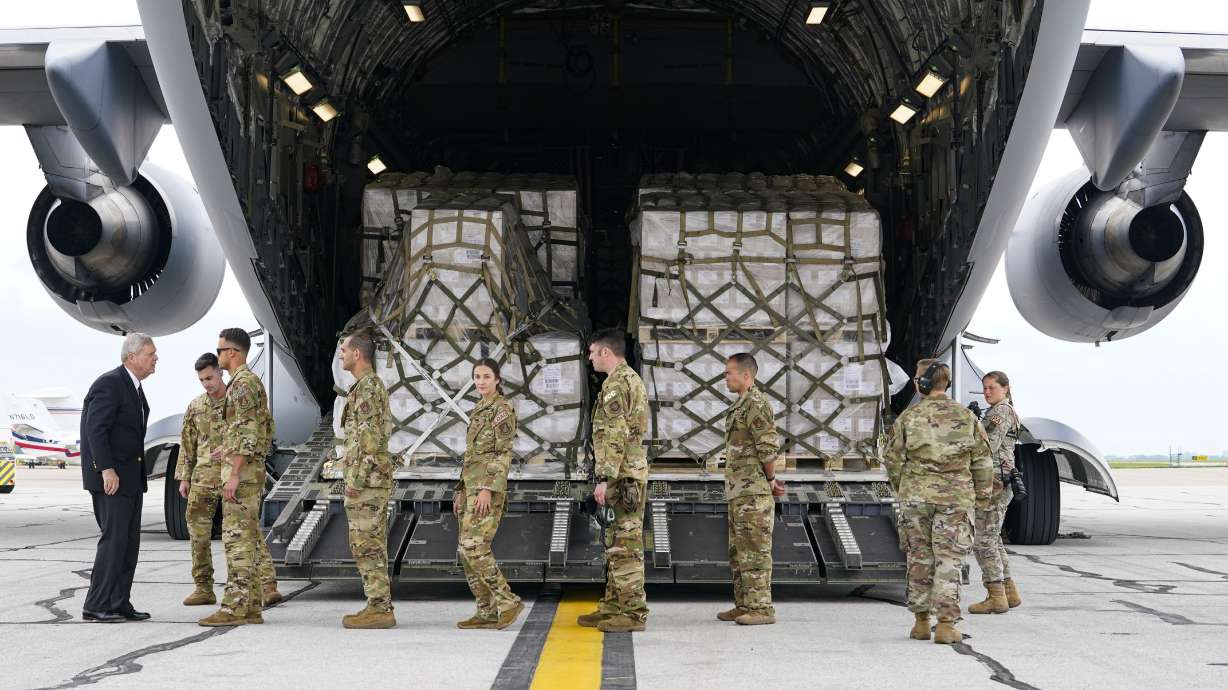 Agriculture Secretary Tom Vilsack, left, greets crew members of a C-17 that delivered a plane load of baby formula at the Indianapolis International Airport in Indianapolis, Sunday. The 132 pallets of Nestlé Health Science Alfamino Infant and Alfamino Junior formula arrived from Ramstein Air Base in Germany.