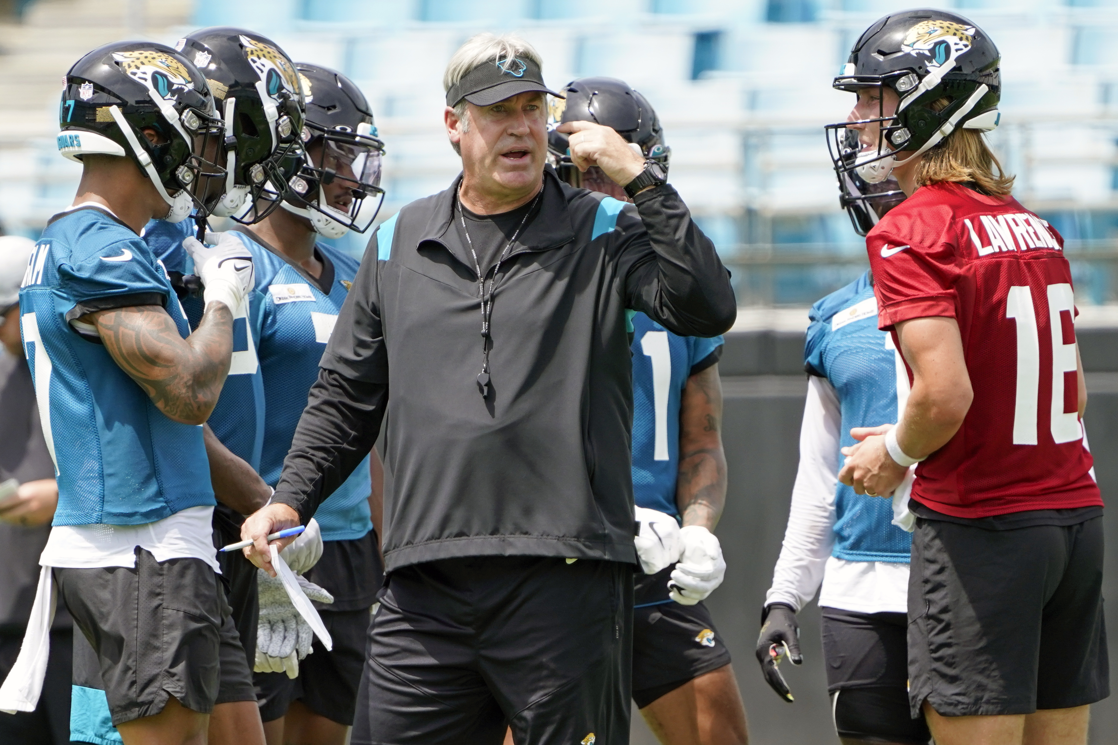 Jacksonville Jaguars head coach Doug Pederson, center, directs an NFL football practice, Monday, May 23, 2022, in Jacksonville, Fla. At right is quarterback Trevor Lawrence.