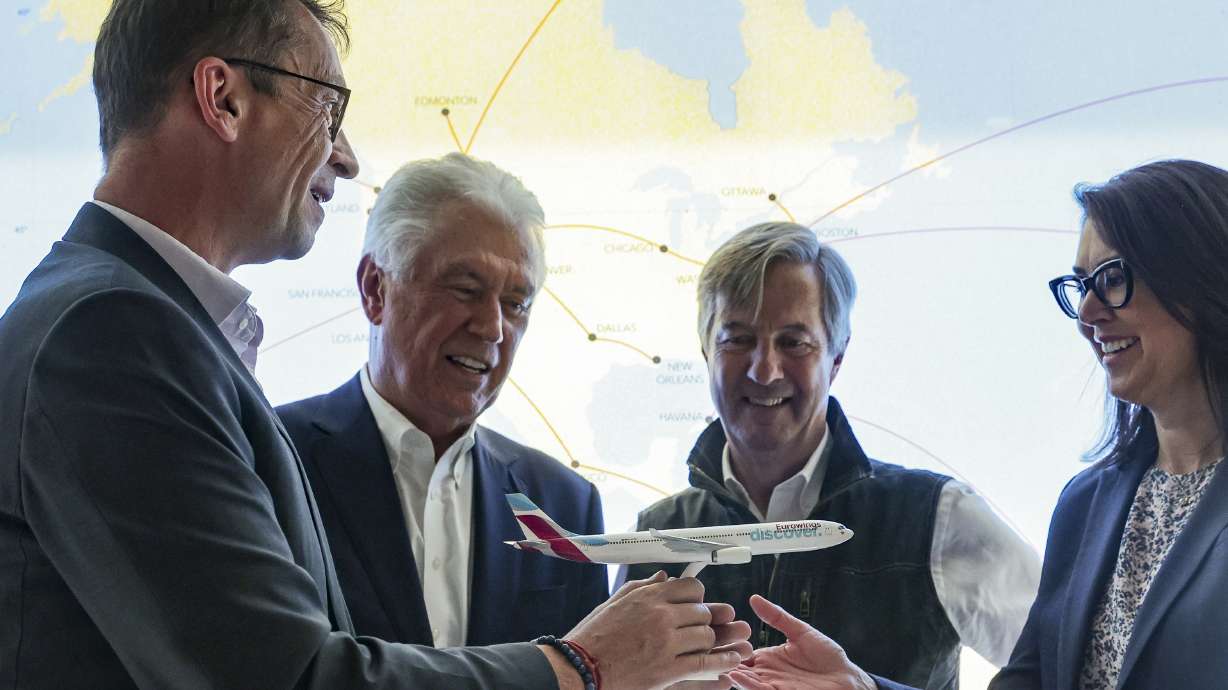 Helmut Woelfel, the CCO of Eurowings Discover, left, hands a Eurowings Discover A-330 model airplane to Utah Lt. Gov. Deidre Henderson during a press conference at the Salt Lake City International Airport in Salt Lake City on Monday.