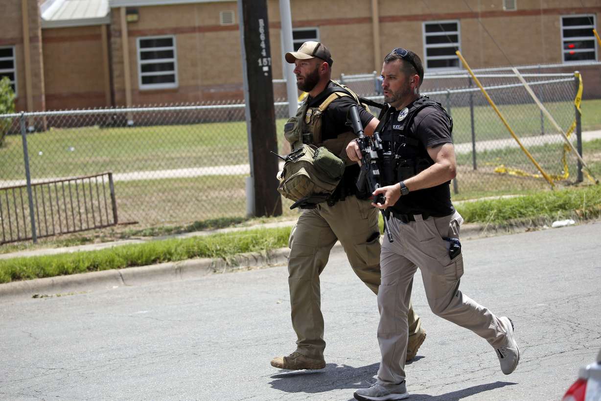 Police walk near Robb Elementary School following a shooting, Tuesday, in Uvalde, Texas.