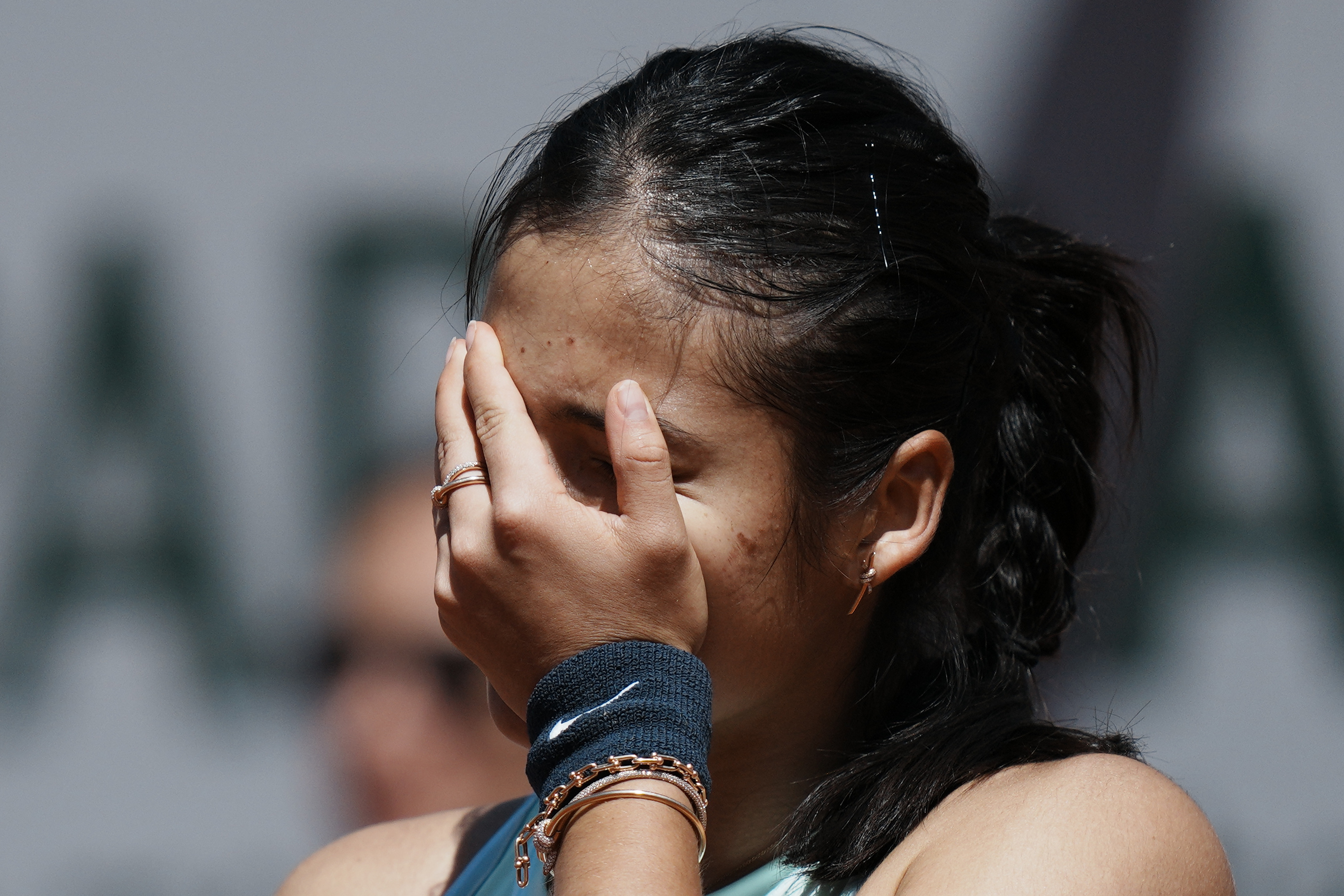 Britain's Emma Raducanu hides her face as she plays Aliaksandra Sasnovich of Belarus during their second round match of the French Open tennis tournament at the Roland Garros stadium Wednesday, May 25, 2022 in Paris. 