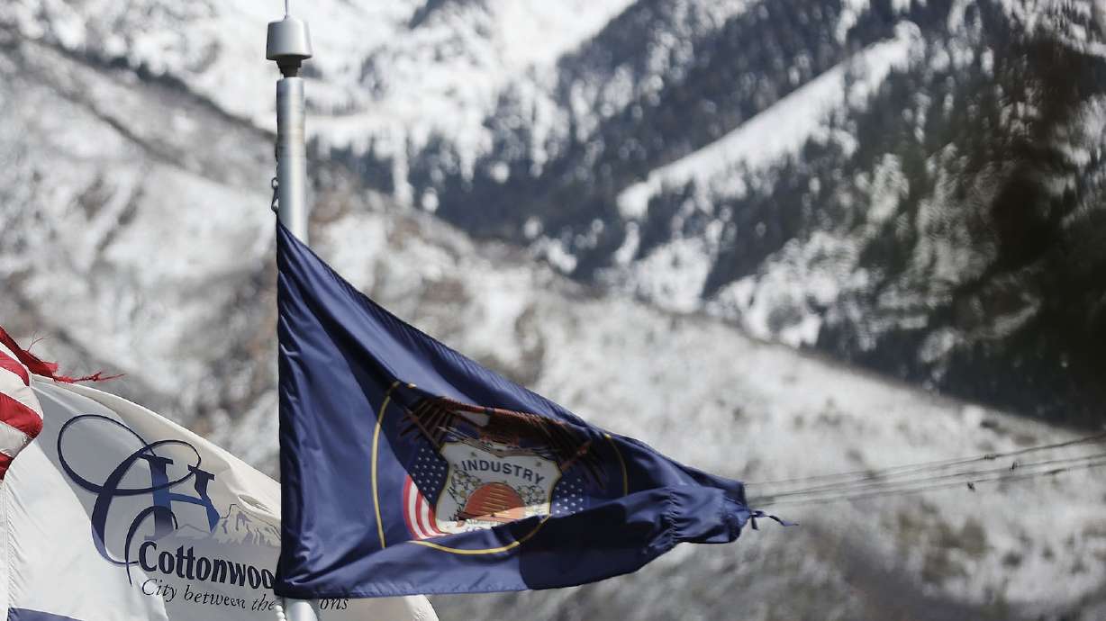 A Utah flag flies in front of mountains in Cottonwood Heights on May 12. Mountains are a popular theme theme among what Utahns told the Utah State Flag Task Force they want in a new state flag.