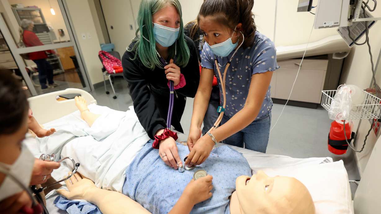Whittier Elementary sixth grade students Emiry Ozmore, left, and Layney Spencer listen to the computer simulated heartbeat of a medical mannequin while visiting the University of Utah College of Nursing for Imagine U. Day in Salt Lake City on Wednesday.