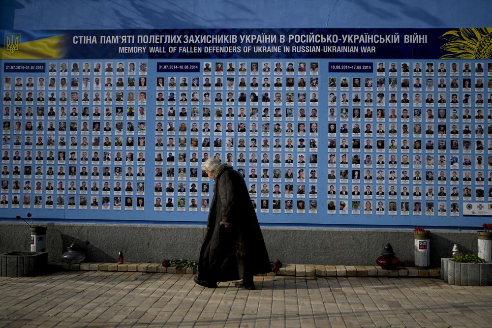 A woman walks past the Memorial Wall of Fallen Defenders of Ukraine in Russian-Ukrainian War in Kyiv, Ukraine, Monday. Everywhere in Ukraine, the 3-month-old war never seems to be far away.