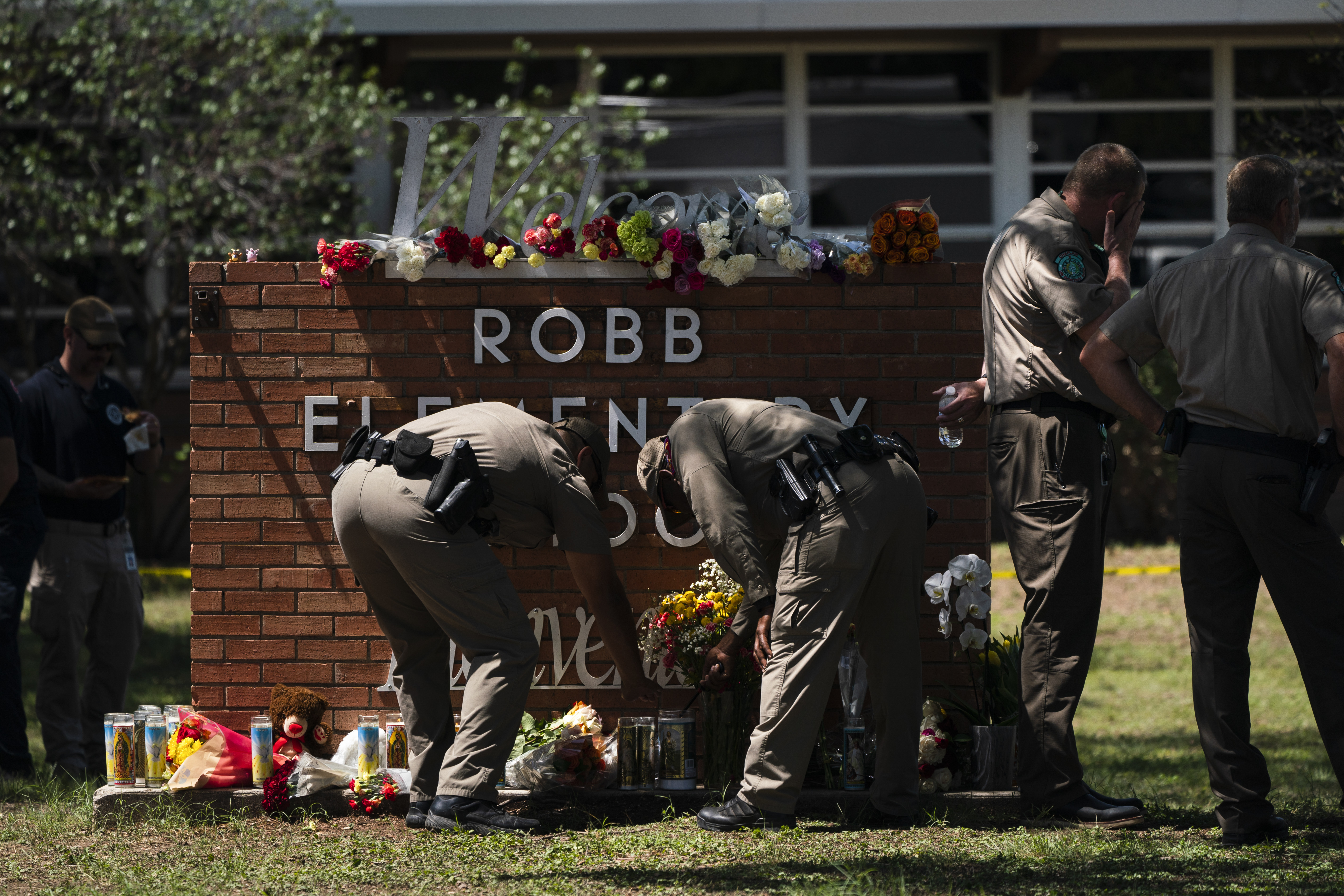Two Texas Troopers light a candle at Robb Elementary School in Uvalde, Texas, Wednesday. A Huntsman Mental Health Institute expert discussed how community members and parents can address mental health struggles and questions following mass shootings.