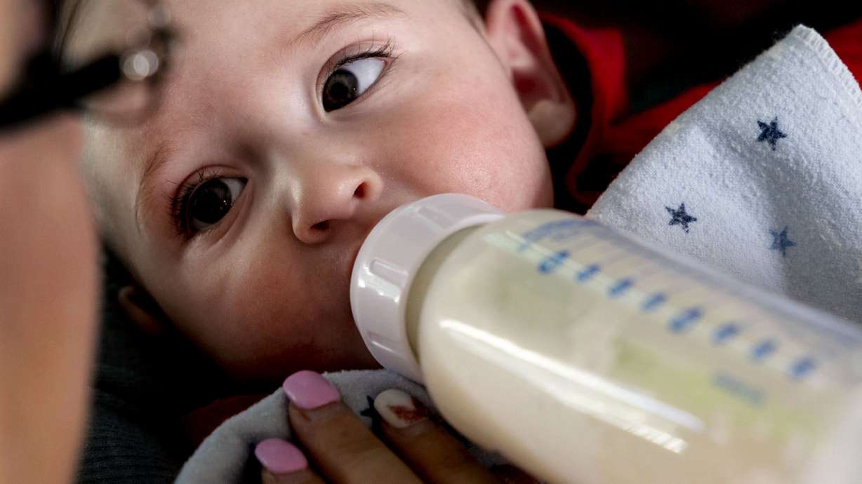 Cyndle Bass feeds 5-month-old Austin formula at their Eagle Mountain home on May 11.