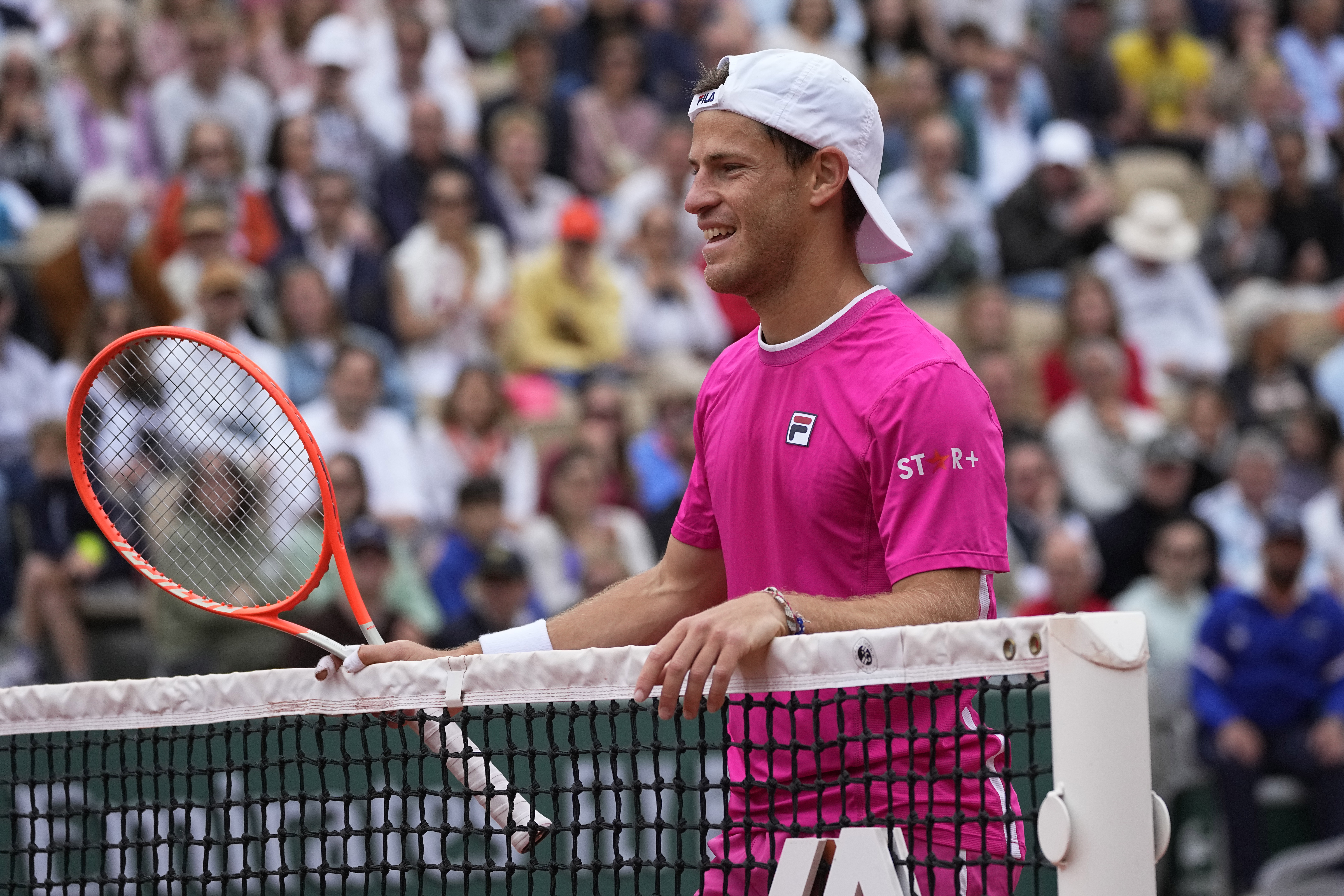 Argentina's Diego Schwartzman smiles at the net as he plays Bulgaria's Grigor Dimitrov during their third round match of the French Open tennis tournament at the Roland Garros stadium Friday, May 27, 2022 in Paris. 