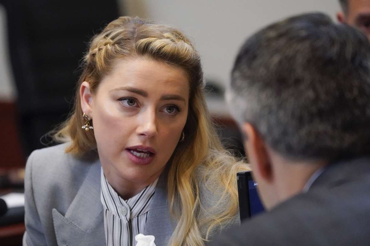 Actor Amber Heard speaks to her legal team in the courtroom at the Fairfax County Circuit Courthouse in Fairfax, Va., Friday. Actor Johnny Depp sued his ex-wife Amber Heard for libel in Fairfax County Circuit Court after she wrote an op-ed piece in The Washington Post in 2018 referring to herself as a "public figure representing domestic abuse."