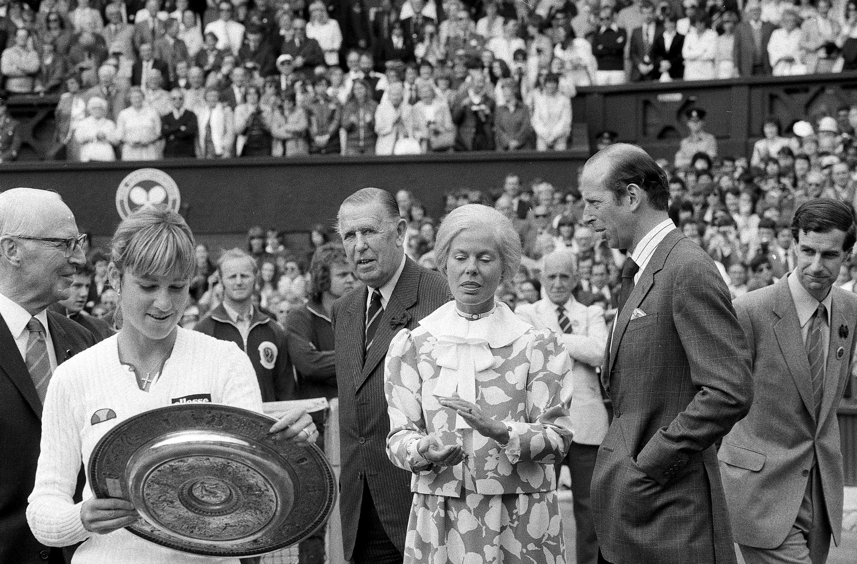 FILE - Chris Evert Lloyd admires her trophy, as the Duchess of Kent applauds, following the presentation ceremony on Wimbledon's Centre Court, Friday, July 3, 1981. Chris Evert appreciates that she, Serena Williams and other Wimbledon women's singles champions will now be listed on the All England Club's honor boards in a Centre Court hallway simply by their first initial and last name — the way the men's title winners always have been — instead of preceded by “Miss” or “Mrs.” 