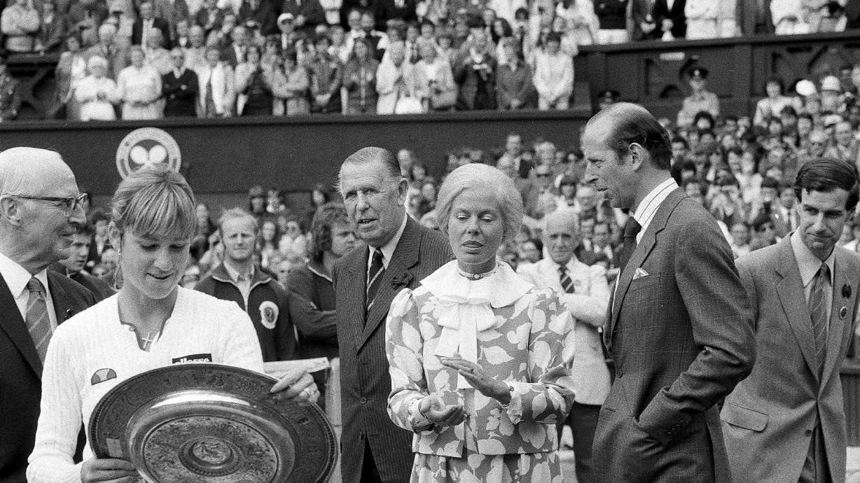 FILE - Chris Evert Lloyd admires her trophy, as the Duchess of Kent applauds, following the presentation ceremony on Wimbledon's Centre Court, Friday, July 3, 1981. Chris Evert appreciates that she, Serena Williams and other Wimbledon women's singles champions will now be listed on the All England Club's honor boards in a Centre Court hallway simply by their first initial and last name — the way the men's title winners always have been — instead of preceded by “Miss” or “Mrs.”