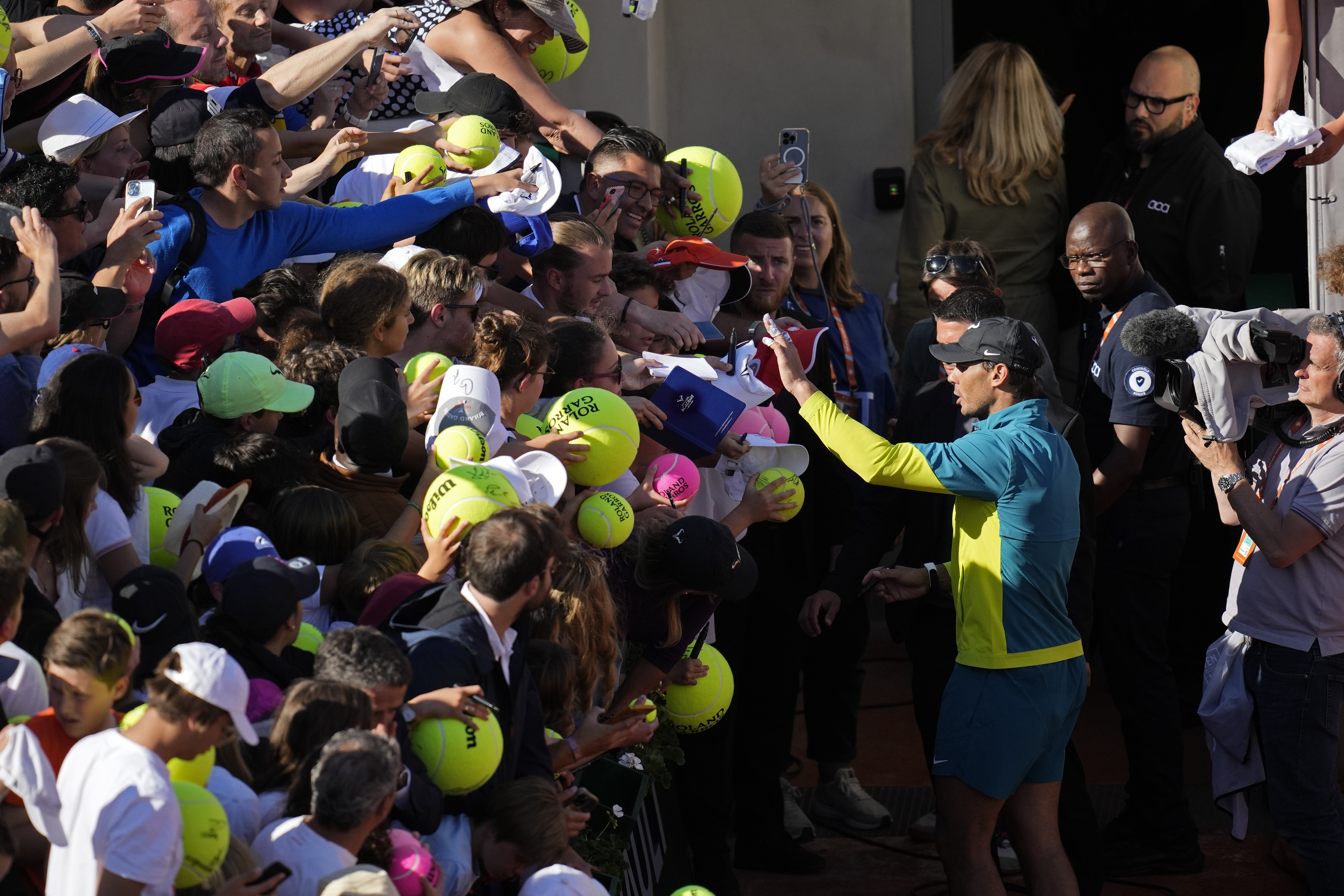 Spain's Rafael Nadal gestures to fans to stay calm as they crush each other lunging forward when trying to get an autograph after his third round match against Netherlands' Botic van de Zandschulp at the French Open tennis tournament in Roland Garros stadium in Paris, France, Friday, May 27, 2022. 
