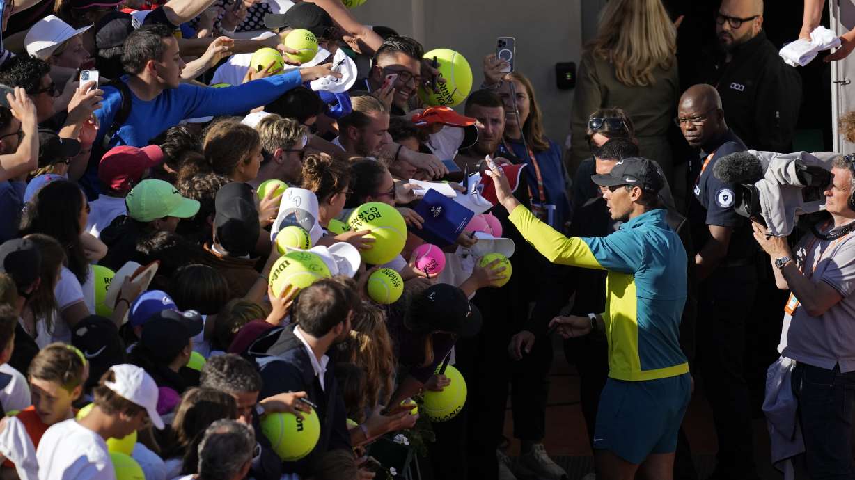 Spain's Rafael Nadal gestures to fans to stay calm as they crush each other lunging forward when trying to get an autograph after his third round match against Netherlands' Botic van de Zandschulp at the French Open tennis tournament in Roland Garros stadium in Paris, France, Friday, May 27, 2022.