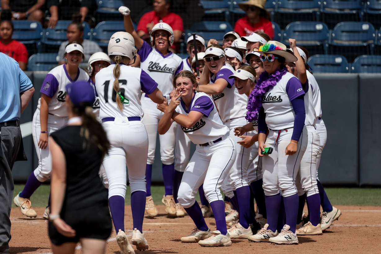 Riverton’s Kyli Carrell is greeted at home by teammates after hitting a home run in the 6A softball state championship against West at Miller Park in Provo on Friday, May 27, 2022.