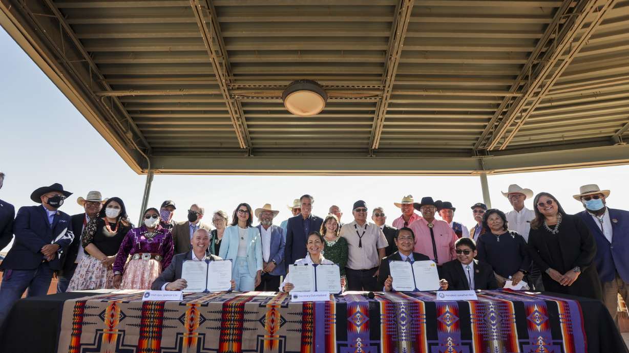 Gov. Spencer Cox, left, U.S. Interior Secretary Deb Haaland and Navajo Nation President Jonathan Nez sign the Navajo Utah Water Rights Settlement Act at the Navajo Welcome Center in Oljato-Monument Valley, San Juan County, on Friday
