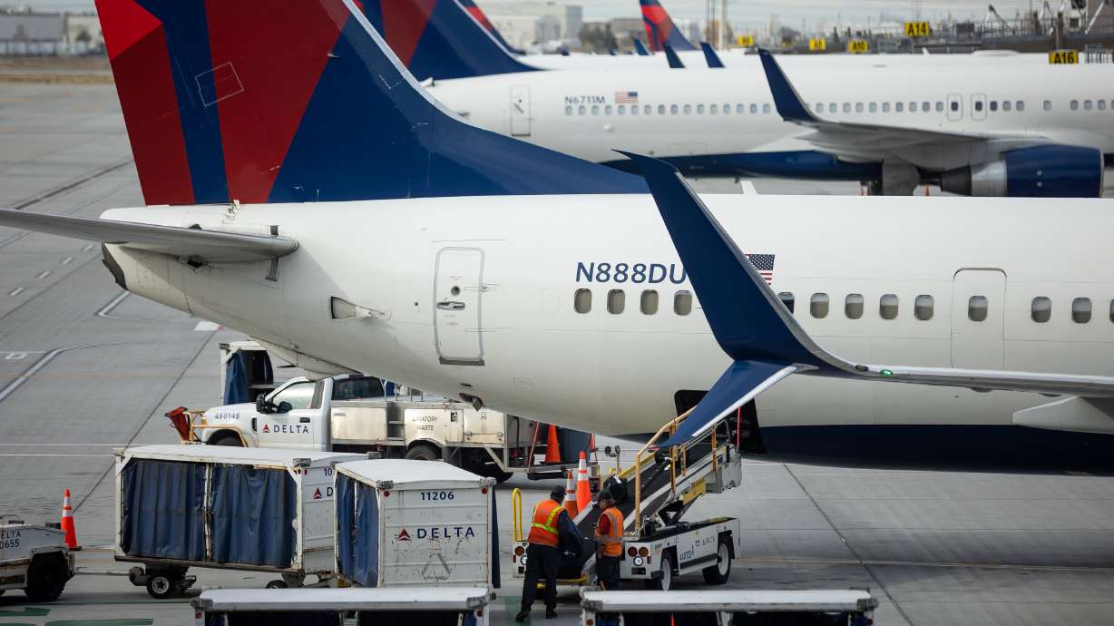 A ground crew loads bags onto a Delta Air Lines jet at Salt Lake City International Airport in Salt Lake City on Nov. 18, 2021. Experts told an eager public jazzed to fly again this summer that things would get chaotic in the skies — and that's exactly how things turned out all summer long.