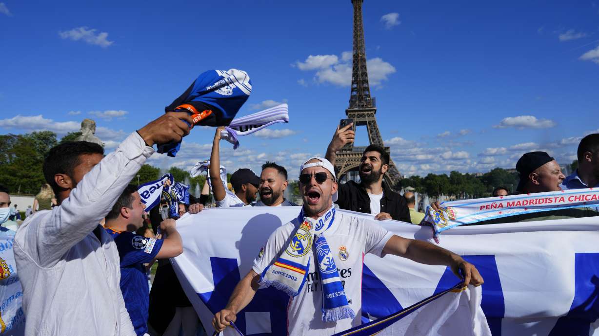 Real Madrid fans cheer in front of the Eiffel Tower Paris, Friday, May 27, 2022. Liverpool and Real Madrid will face each other in the Champions League final soccer match on Saturday.